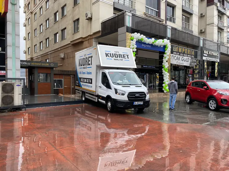 Yağmurlu bir günde dükkân önünde yapılan işyeri taşıması